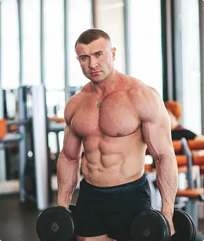 Muscular Male Bodybuilder Training Hard At Gym